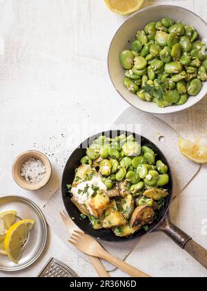 Fèves au citron servi avec pommes de terre rissolées, harissa et persil Banque D'Images