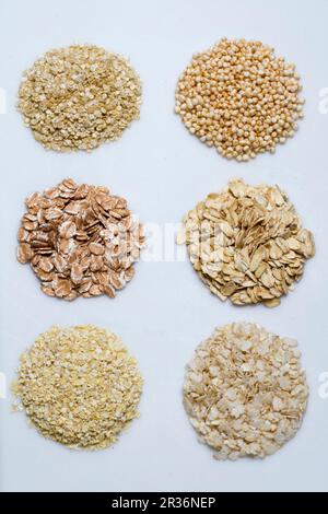 Six piles de grains divers sur une surface blanche Banque D'Images