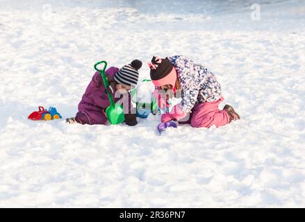 Les enfants jouent sur la neige Banque D'Images