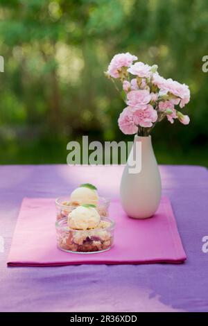 Crumble aux fraises avec glace à la vanille en dessert plats sur une table de jardin Banque D'Images