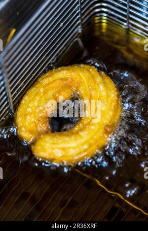 Un churro dans une friteuse avec de l'huile Banque D'Images