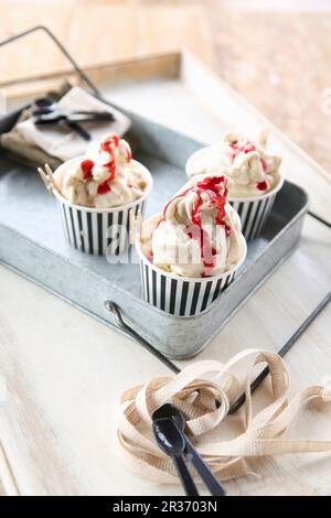 Crème glacée à la framboise dans des gobelets en papier sur un plateau métallique Banque D'Images