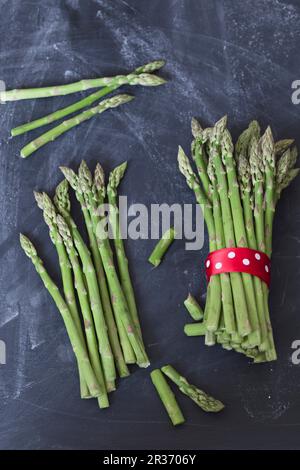 Asperges vertes, certaines dans des petits pains Banque D'Images