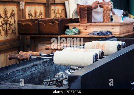 Kürtőskalács (ou kurtos kalacs) gâteau de cheminée, un dessert typique de Budapest, sur un grill au charbon de bois Banque D'Images