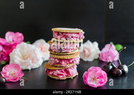 Une pile de sandwichs gaufrés à la crème glacée aux cerises Banque D'Images