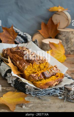 Un gâteau de citrouille en tranches sur fond d'automne Banque D'Images