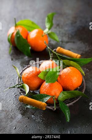 Mandarines avec feuilles dans un panier Banque D'Images