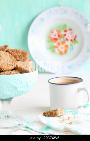 Un bol de biscuits sans gluten avec de la farine de sarrasin et du sucre en fleur de coco, et du café dans une tasse en émail Banque D'Images