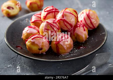 Beignets fourrés à la confiture avec un glaçage au sucre rose Banque D'Images