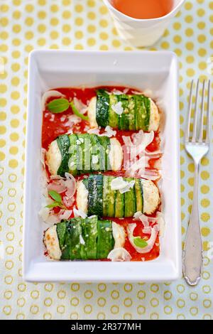 Rouleaux de courgettes avec du fromage frais garniture sur la sauce tomate Banque D'Images