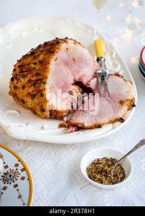 Jambon glacé et moutarde épaisse garni d'œillets Banque D'Images