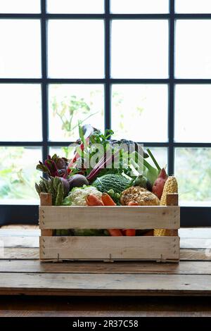 Une caisse de légumes devant une fenêtre Banque D'Images