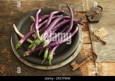 Des aubergines longues et fines sur une assiette Banque D'Images