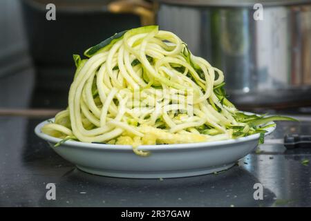 Zoodles (nouilles courgettes spiralées) sur une assiette dans la cuisine Banque D'Images