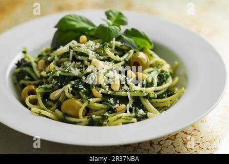 Spaghetti au pesto d'épinards et d'olives vertes Banque D'Images