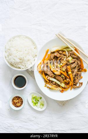 Sauté de bœuf avec carotte et oignon de printemps servi avec du riz (Chine) Banque D'Images