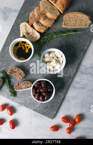 Mezze grec : olives, feta, huile d'olive et pain Banque D'Images