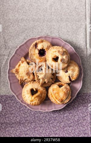 Faire cuire les petites tartes sur une assiette de lilas (vue de dessus) Banque D'Images