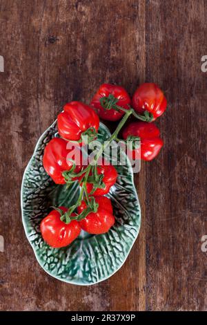 Petites tomates prune dans un bol en céramique Banque D'Images