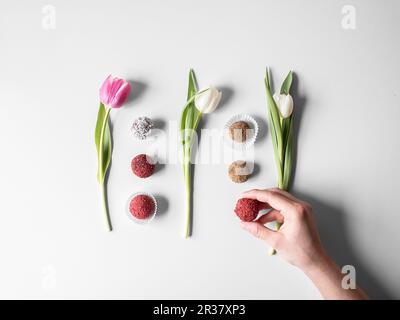 Diverses pralines disposées entre des tulipes (vu d'en haut) Banque D'Images