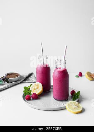 Réglisse rose et smoothie à la framboise servis dans des bouteilles de verre Banque D'Images