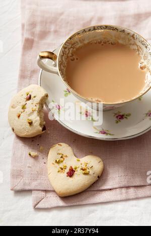 Biscuits avec pistaches et pétales de rose séchés, servis avec une tasse de café Banque D'Images