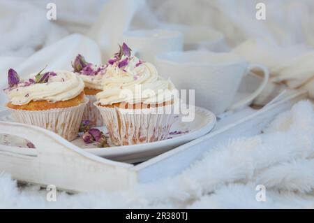 Petits gâteaux à la vanille aux pétales de rose séchés sur un plateau blanc Banque D'Images