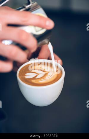 Un barista qui fait du latte Banque D'Images