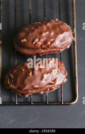 Biscuits aux noix enrobés de chocolat sur une grille de refroidissement Banque D'Images