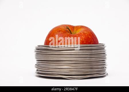 Apple filaire : ensemble pomme rouge dans des bobines de fil aluminium isolé sur fond blanc Banque D'Images