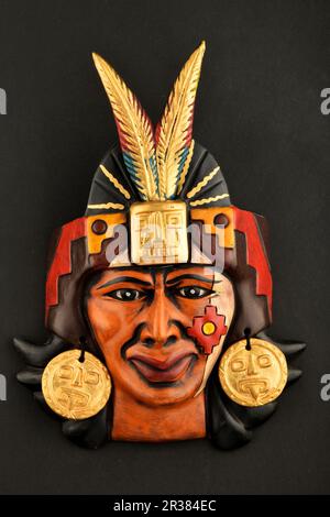 Masque en céramique Aztec maya indien avec plume isolée sur noir Banque D'Images