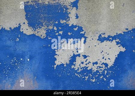 Flocons de vieille peinture bleu sur mur de béton gris Banque D'Images