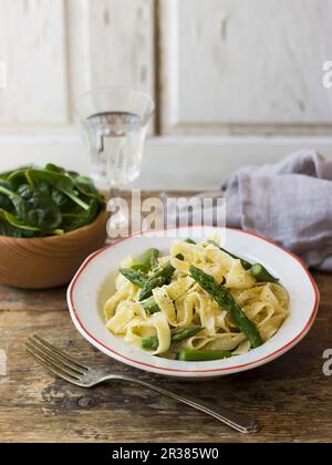 Fettuccine Alfredo : tagliatelle aux asperges vertes et jeunes épinards à feuilles Banque D'Images