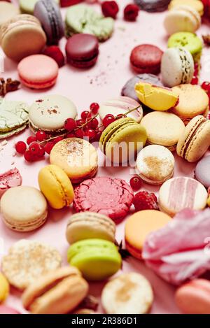 Encore vie de différentes variétés de macarons français sur fond rose Banque D'Images