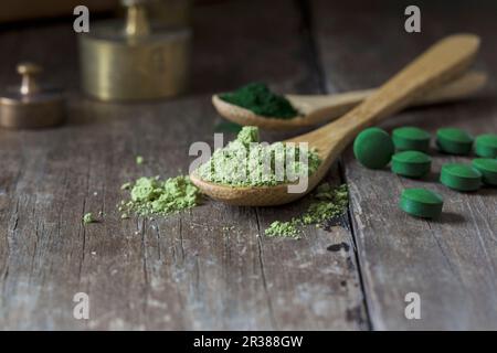 Comprimés de spiruline et poudre de spiruline sur des cuillères en bois Banque D'Images