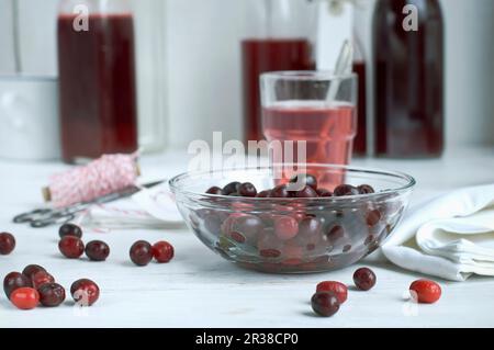 Cerises cornéennes dans un intestin de verre et sirop en bouteilles Banque D'Images