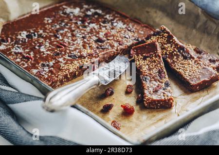 Barres de chocolat maison avec raisins secs, graines de sésame et flocons de noix de coco Banque D'Images