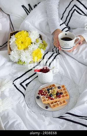 Petit-déjeuner au lit avec du café et des gaufres avec les baies fraîches Banque D'Images