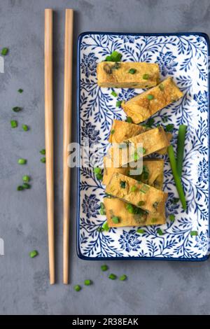 Omelette japonaise laminée (Tamagoyaki) avec ciboulette fraîche (Japon) Banque D'Images