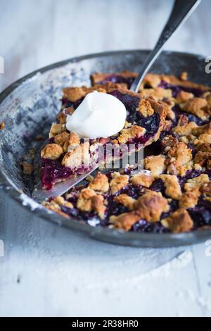 Tarte aux myrtilles avec flocons d'avoine croquants et crème Banque D'Images