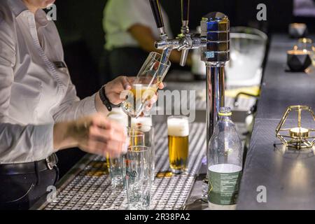 06.07.2019 Koblenz Allemagne main avec une bouteille de liqueur d'alcool de noisette versée dans un verre à liqueur isolé lors d'un mariage de fête. Banque D'Images