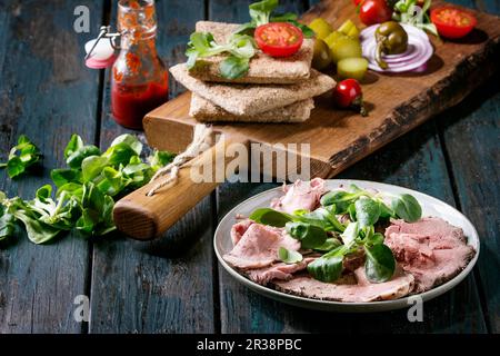Ingrédients pour les sandwichs : viande de bœuf tranchée, pain de seigle entier, salade verte, tomates, concombre mariné, oignon Banque D'Images