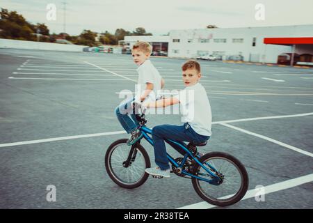 Trucs et astuces des frères à cheval sur un vélo d'ensemble Banque D'Images