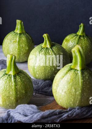 Courgettes rondes crues sur table en bois Banque D'Images