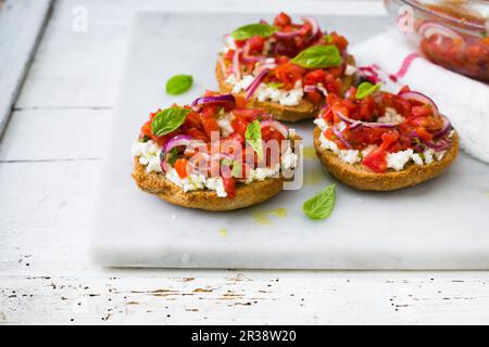 Friselle aux tomates, oignons, basilic et mozzarella Banque D'Images