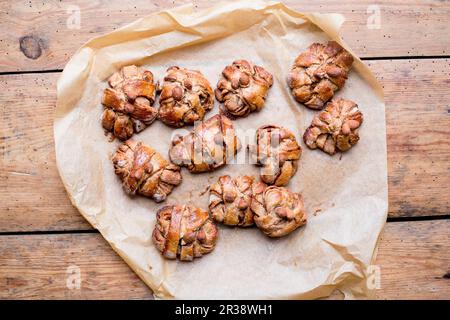 Petits pains à la cannelle et à la cardamome sur du papier de cuisson Banque D'Images