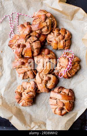 Petits pains à la cannelle et à la cardamome sur du papier de cuisson Banque D'Images