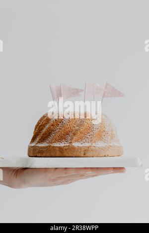 Un gugelhupf décoré de sucre en poudre et de drapeaux en papier Banque D'Images