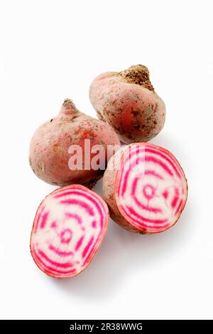 Betteraves Chioggia, entières et coupées en deux sur fond blanc Banque D'Images