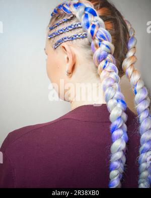 Cornrows femmes Une femme avec une coupe de cheveux sur un fond blanc, des tresses serrées tressées dans une queue, matériel artificiel tissé dans lui Banque D'Images